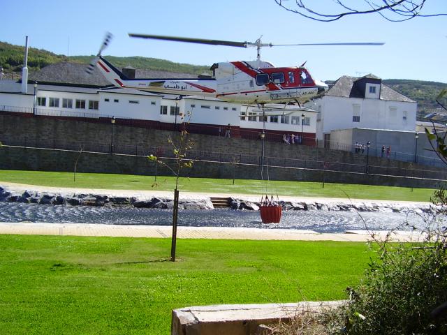 helicoptero cogiendo agua en la playa fluvial 